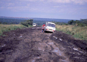 Two men push vans stuck in the mud in Kenya in 1988. Taken with a Pentax K1000.